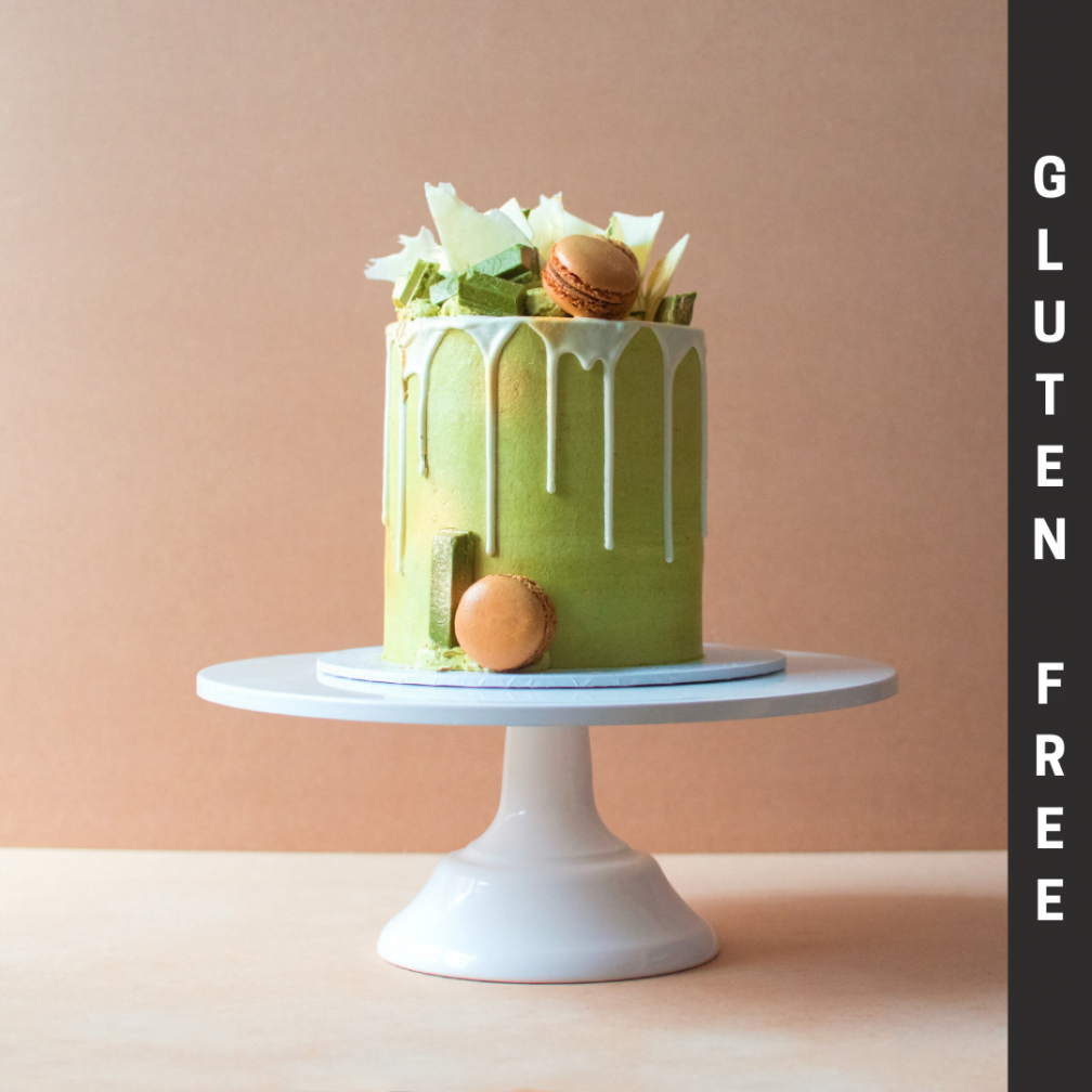Gluten Free matcha green tea cake with white chocolate drip and macarons
