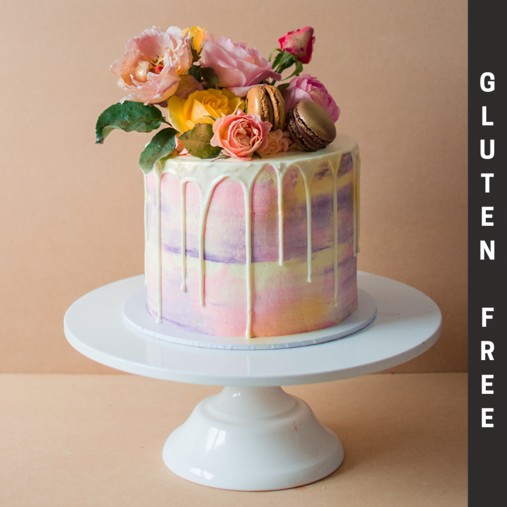 Gluten free pink and purple white chocolate drip cake with flowers