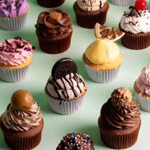 Assorted cupcakes of chocolate and vanilla base arranged in a line. Flavour flavours present