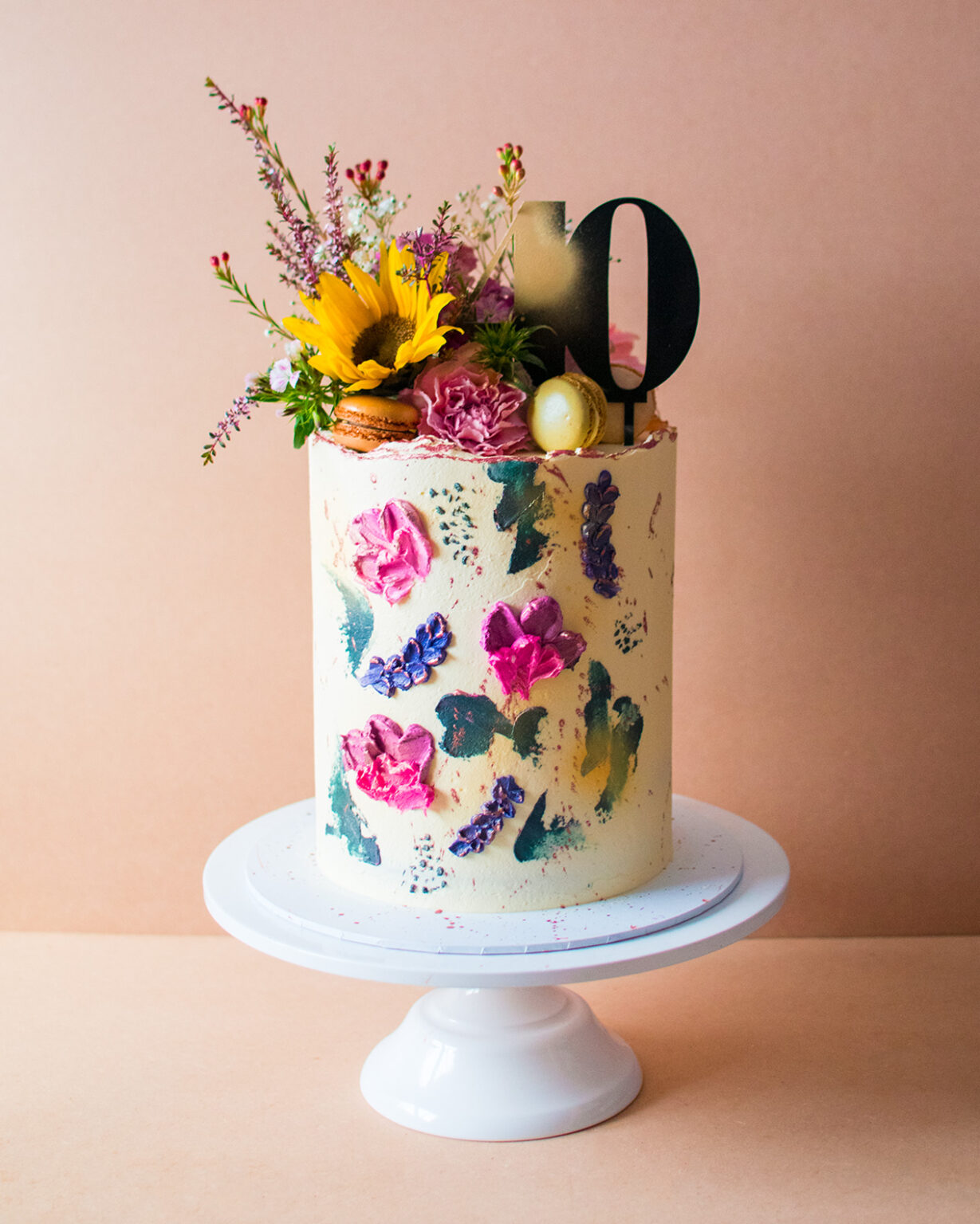 White buttercream cake with buttercream flowers and sunflower on top