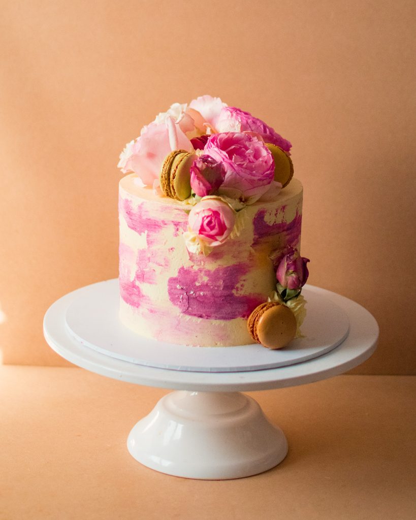 an image a cake with pink watercolour and pink flowers on top