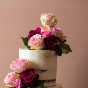 Close up of semi-naked wedding cake with roses