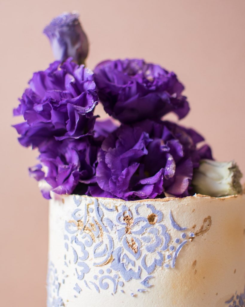 White frosted cake with purple flowers