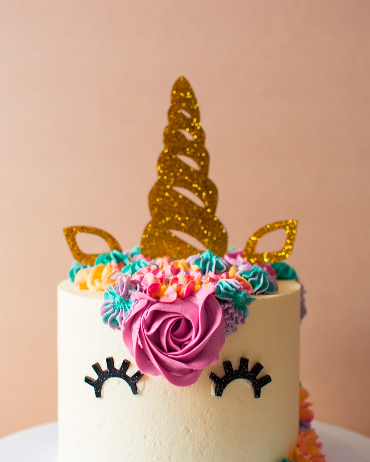 a close up image of an unicorn cake with colourful icing for a birthday